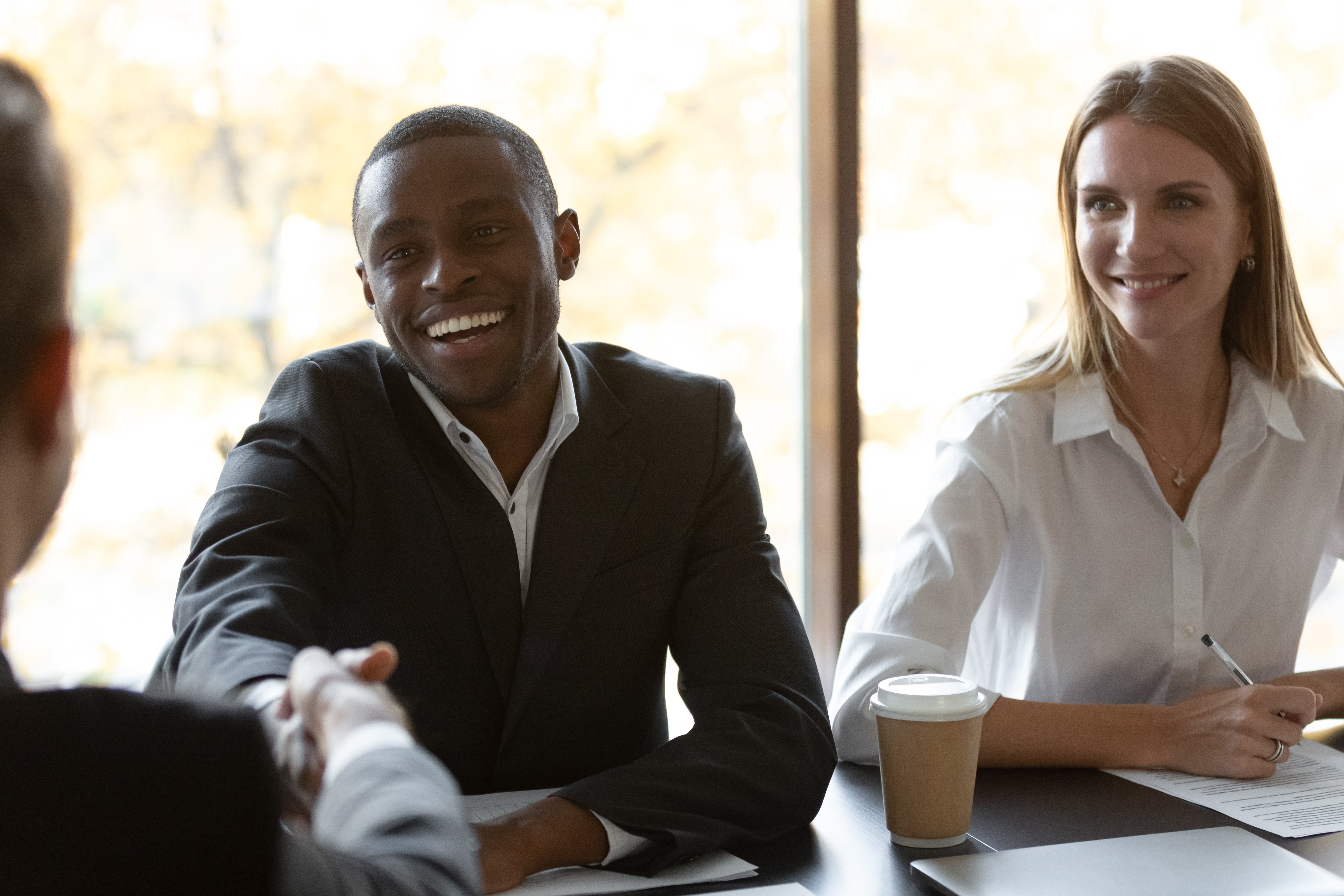 man shaking hands with man during negotiation