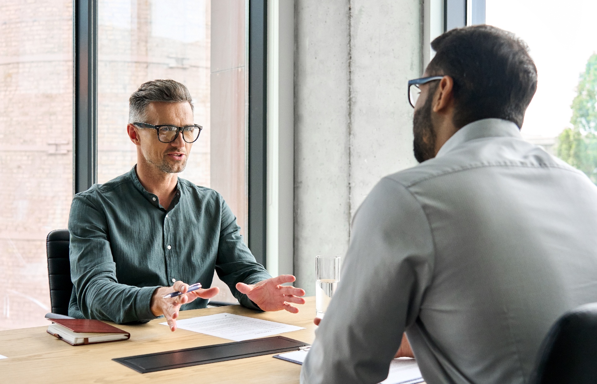 A man negotiates terms and pricing with a salesman.