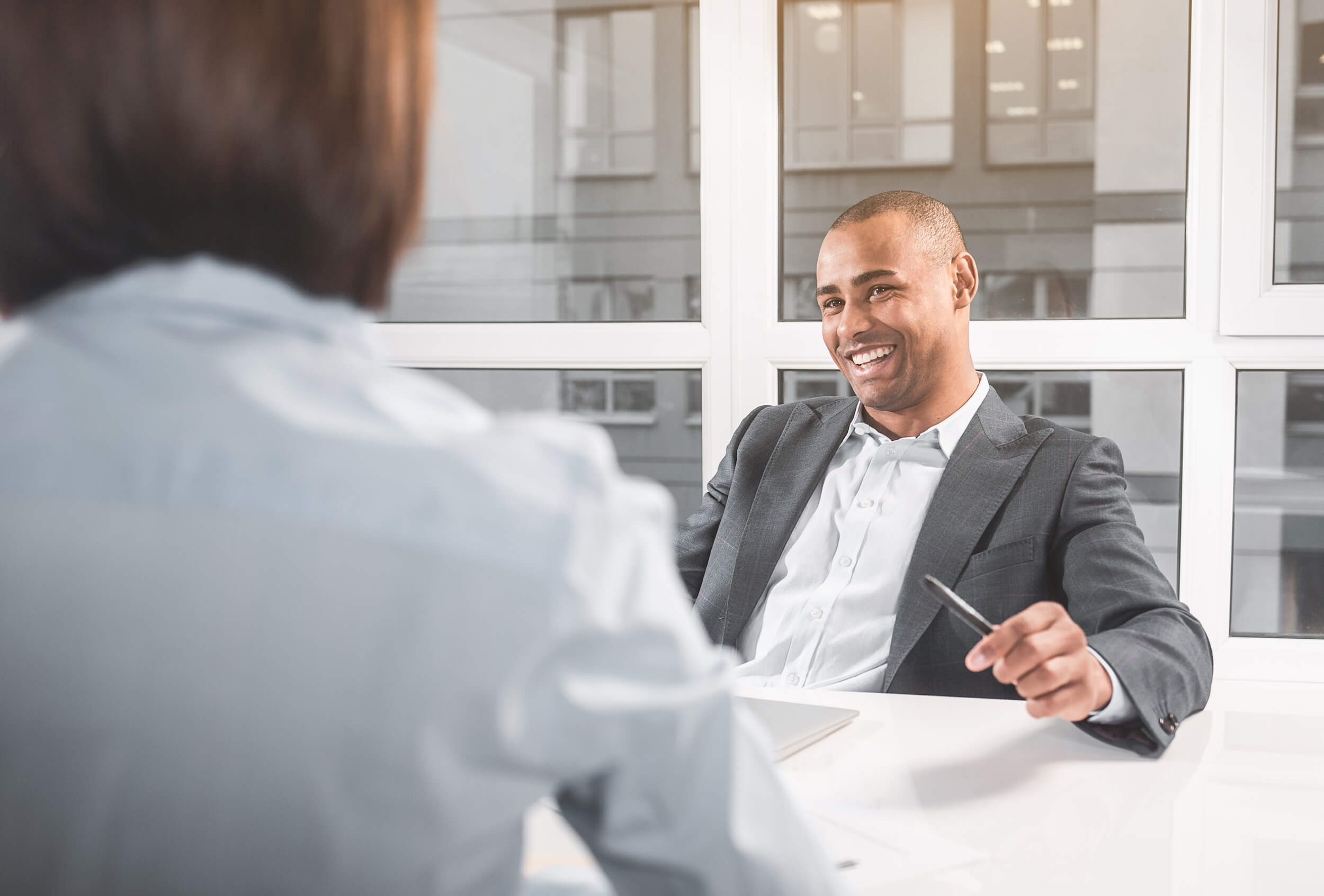 A man sitting in a conference room and engaging in a negotiation with his counterpart. 