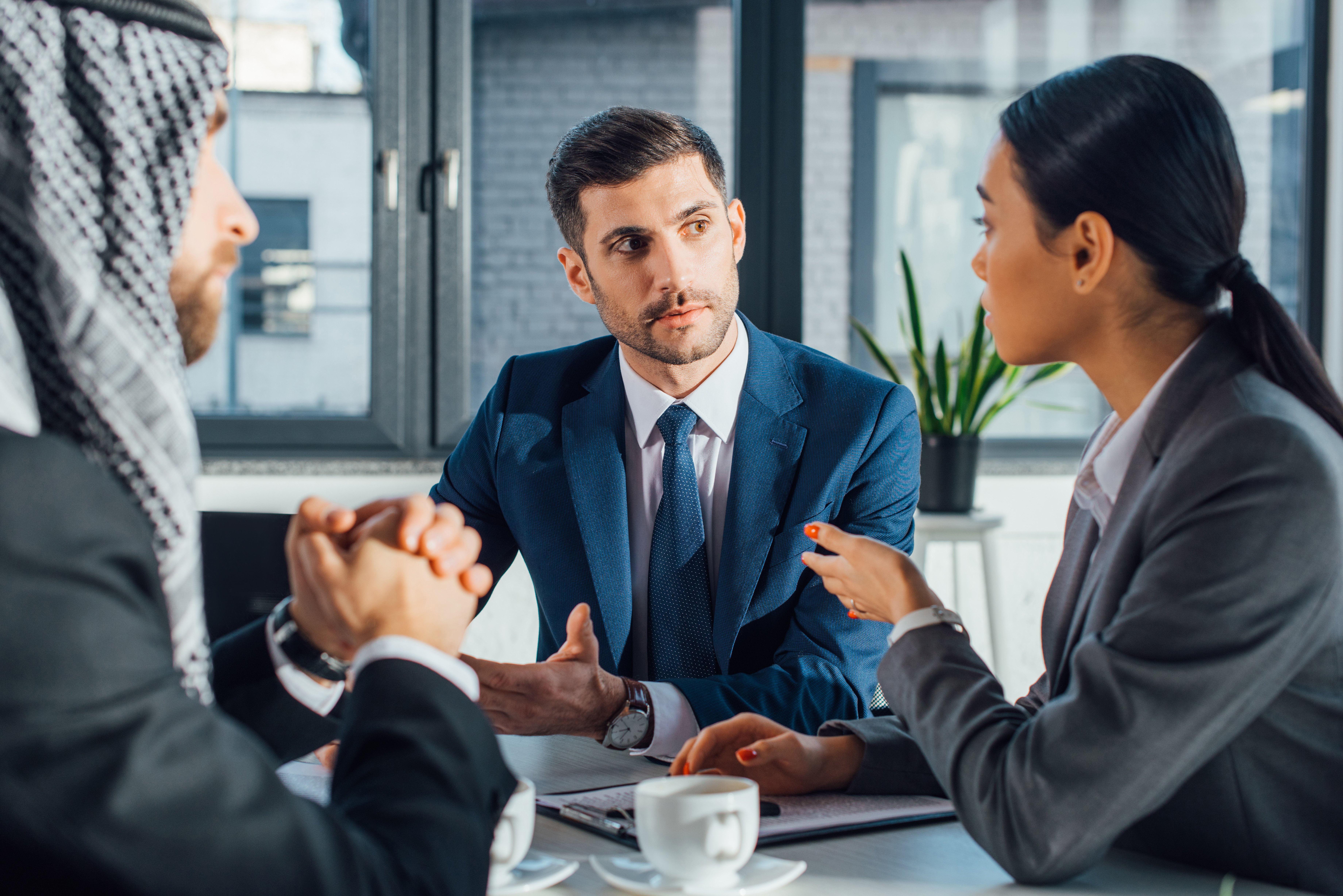 two men and one woman from different countries negotiate a contract 