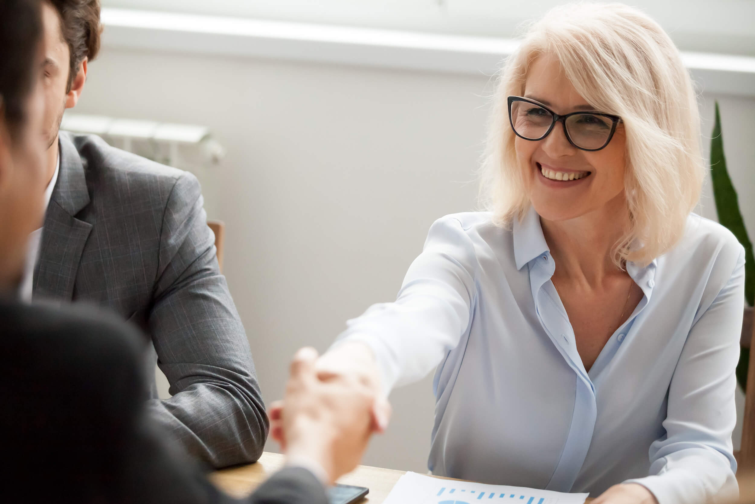 A businesswoman shaking hands with her counterpart. 