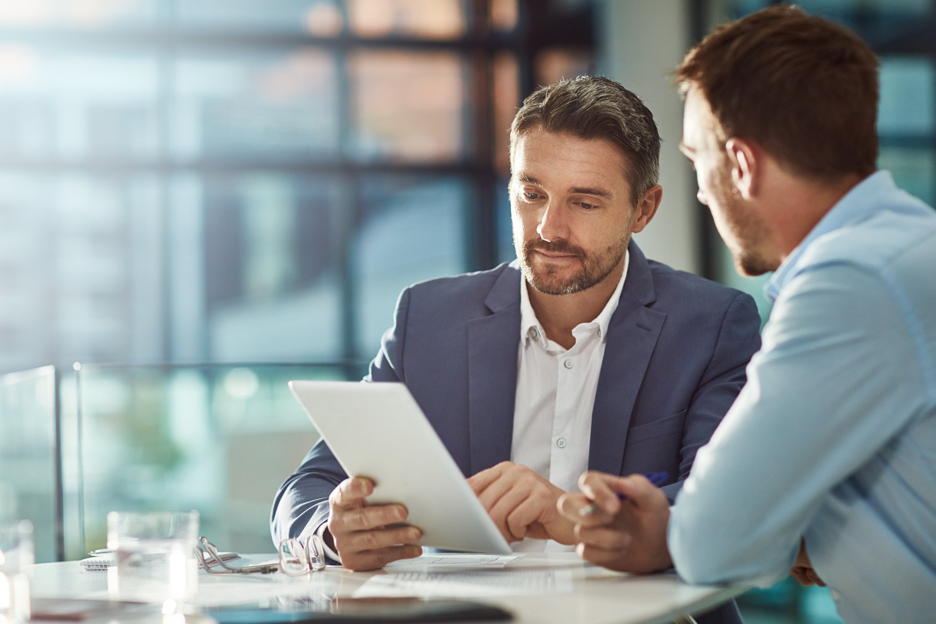 Two business men review terms of a contract after a negotiation.