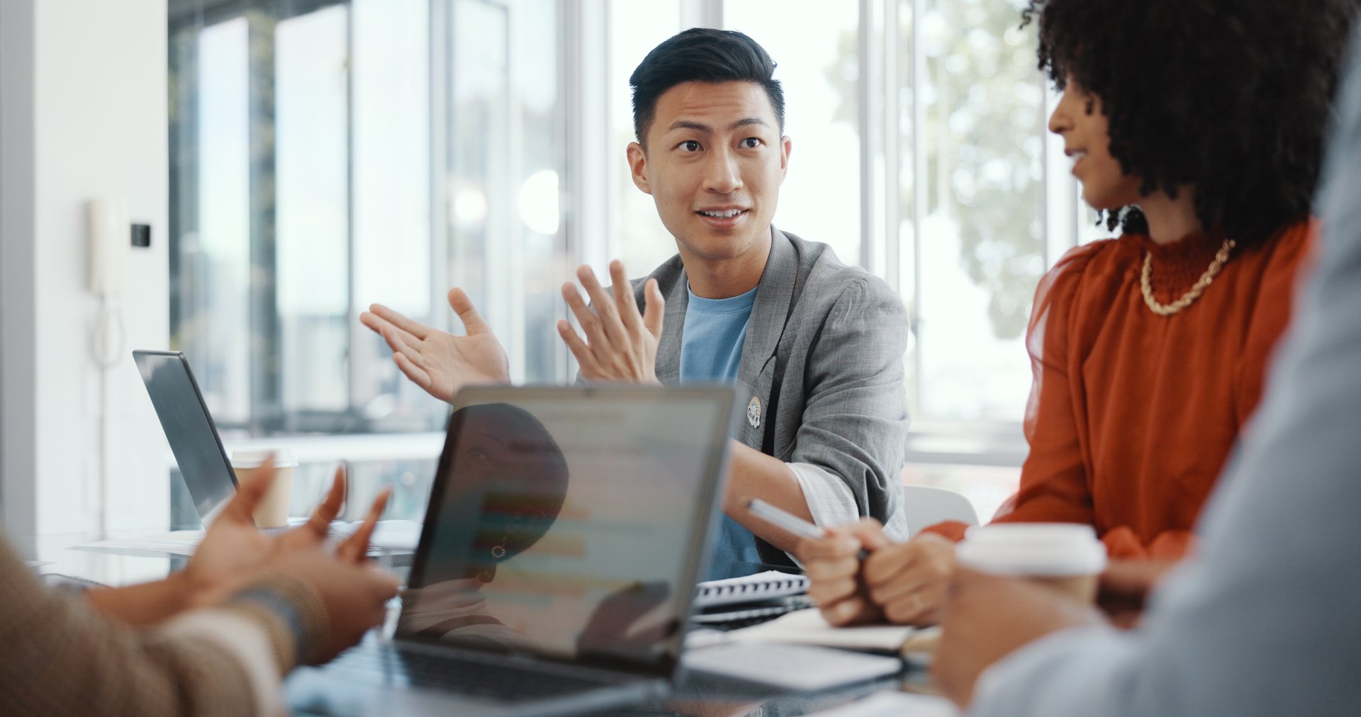 A business man explains his position to counterparts during a negotiation.