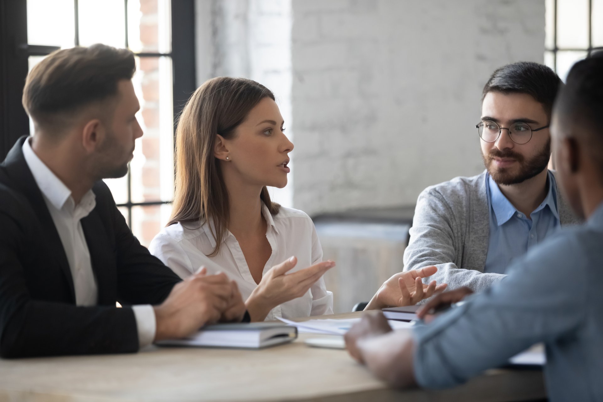 A group of business people negotiate over terms of a contract in an office.