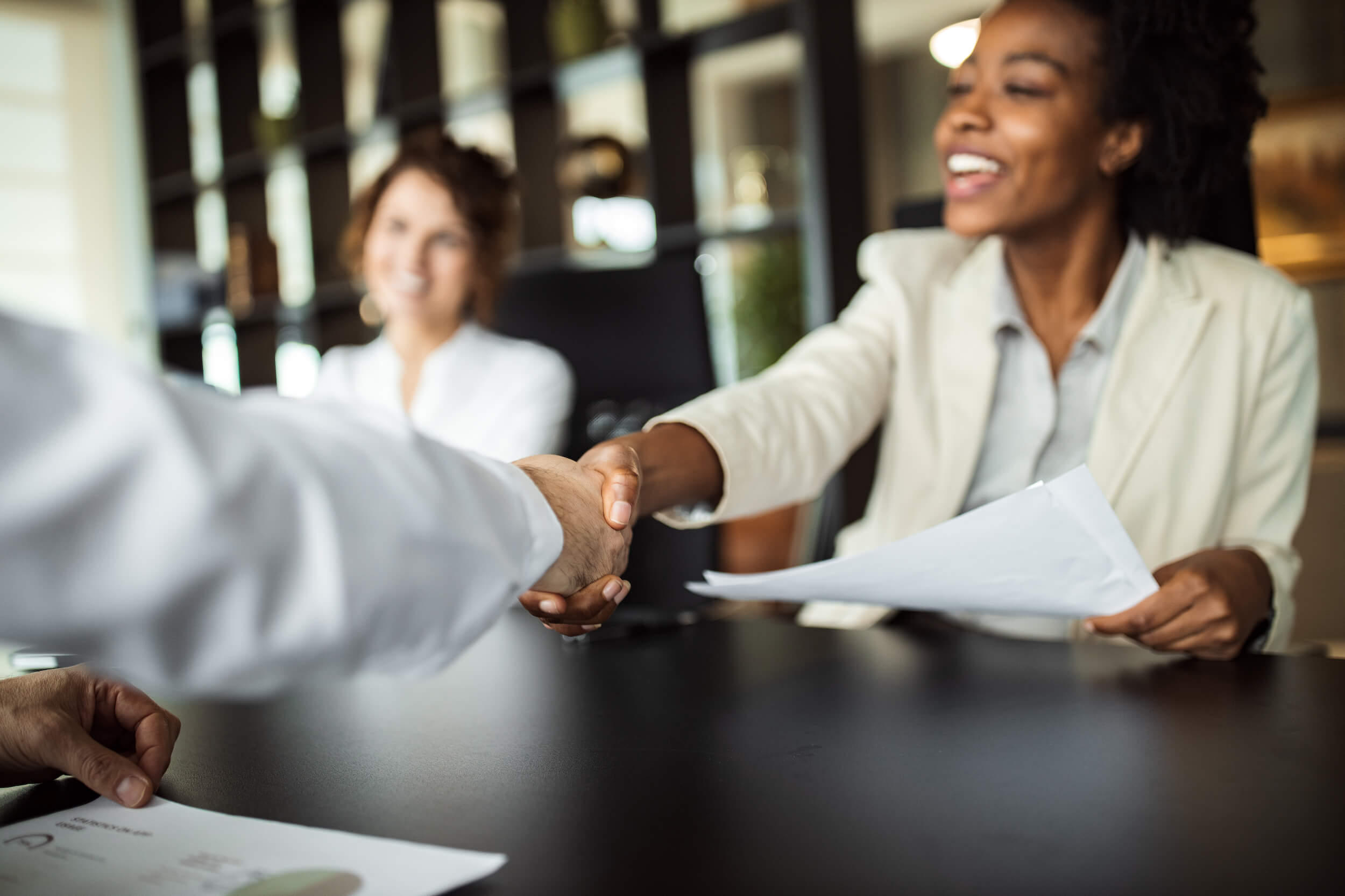 A businesswoman shaking hands with her counterpart. 